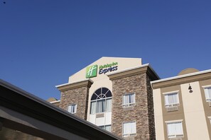 A hotel with a Holiday Inn Express sign, featuring a stone facade and multiple windows.