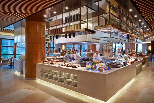 Un restaurante moderno con una barra central, varias estanterías con frascos y vistas al exterior.