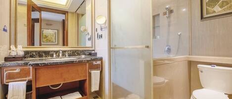 A modern bathroom with a glass-enclosed shower, a marble sink, and a toilet.