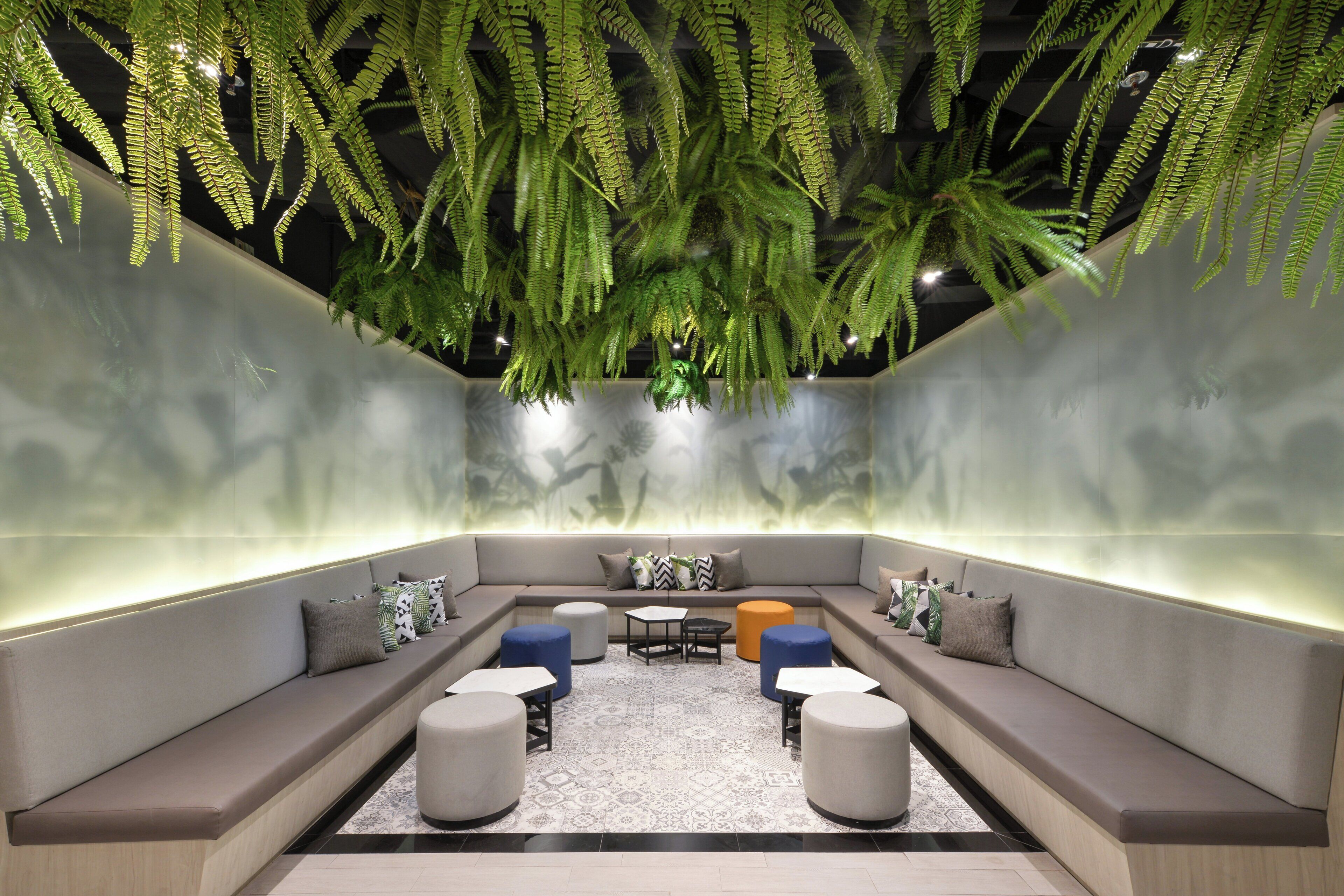 Uma área de estar moderna com sofá, pufes e mesa de centro.