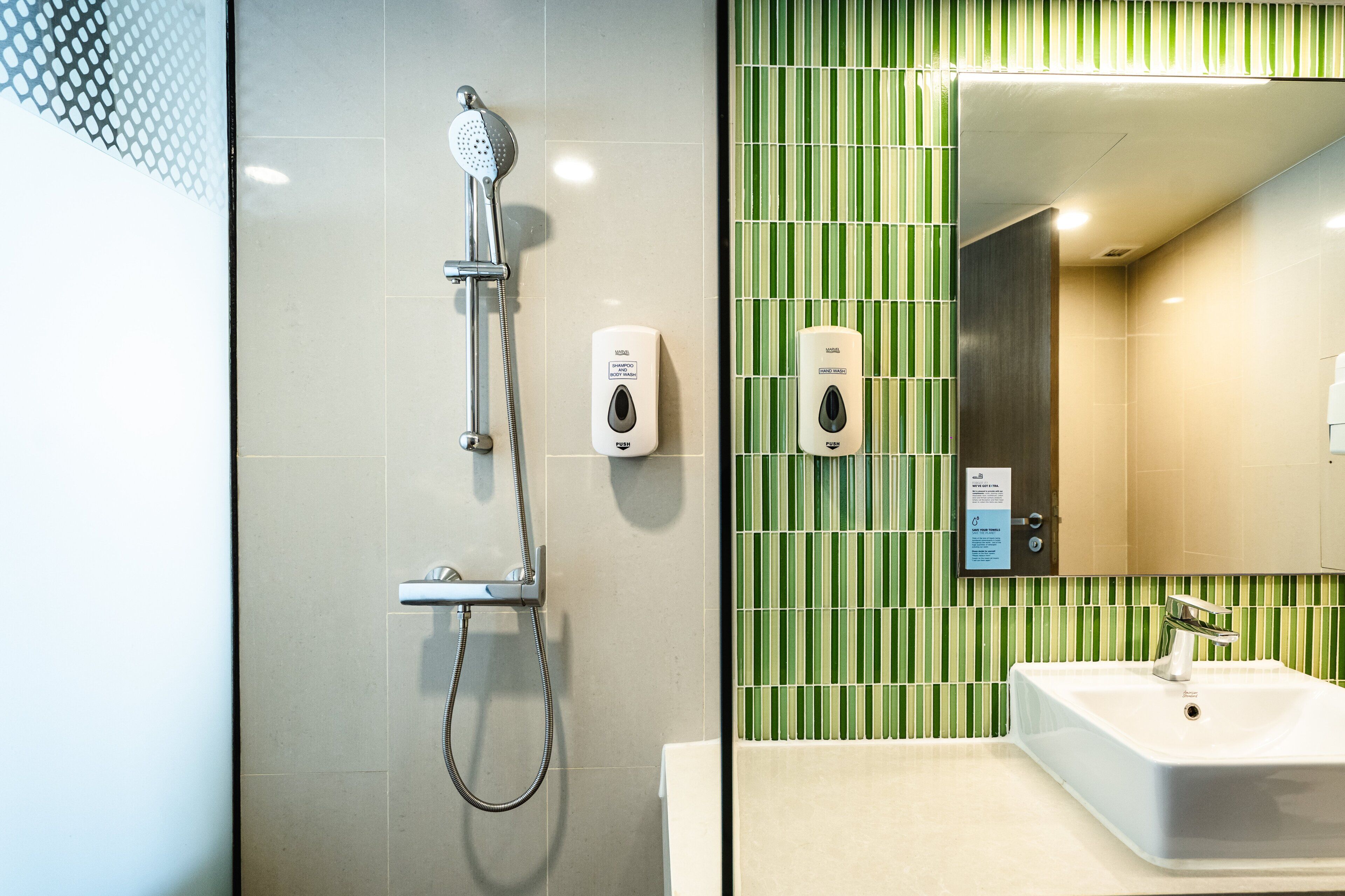 Ein Badezimmer mit Dusche, Waschbecken und Spiegel.