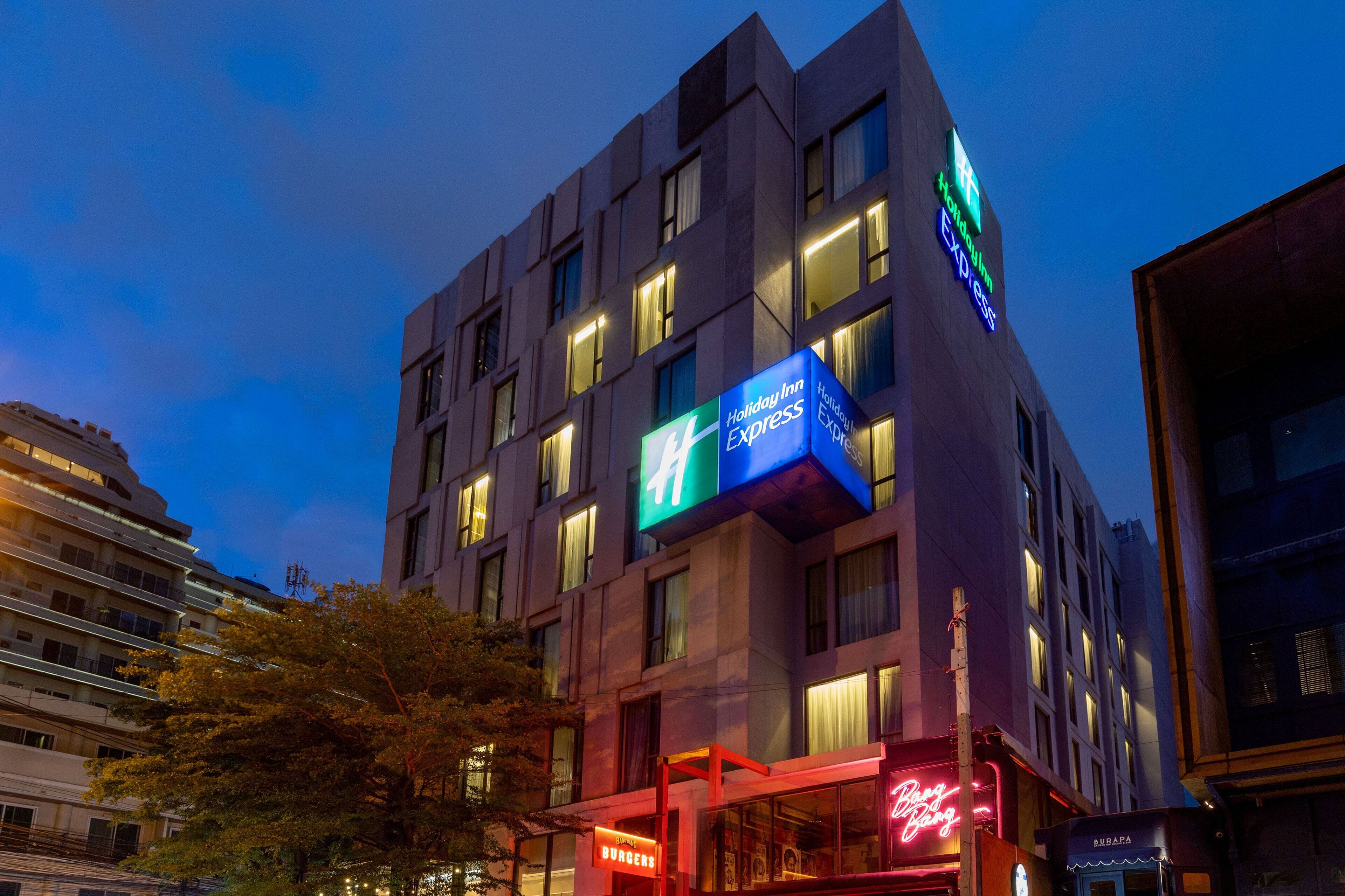 A modern building with illuminated signs for Holiday Inn Express and Burger King.