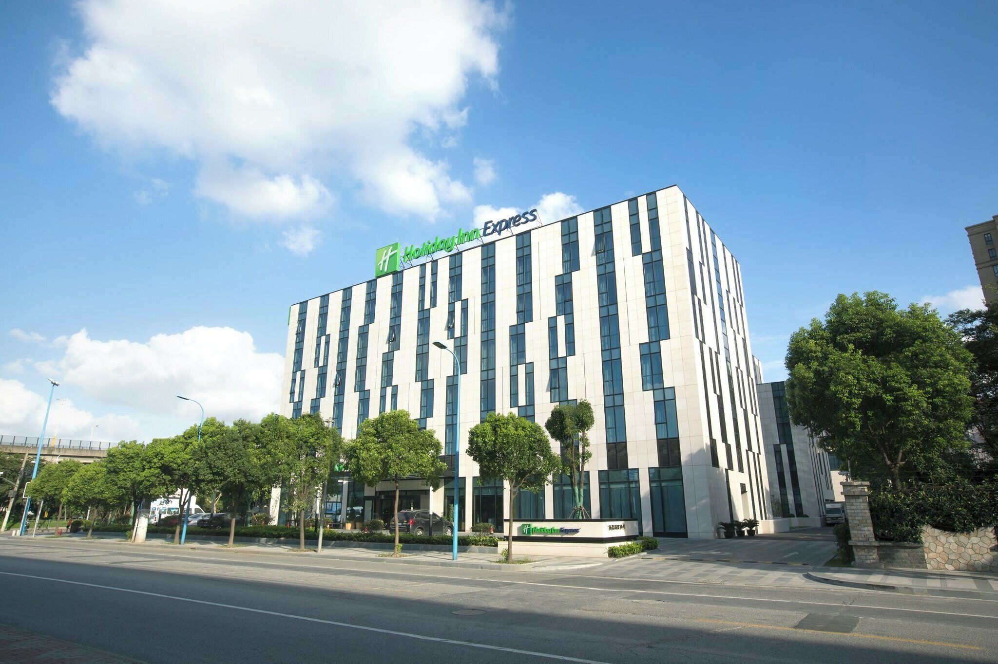 A modern building with a Holiday Inn Express sign, featuring a grid-like facade with large windows and a flat roof.