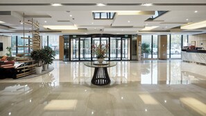 A spacious lobby with a central round table, seating area with sofas, and a reception desk. - Holiday Inn Express Shanghai Gongkang by IHG (Shanghai)