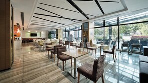 A modern indoor dining area with a mix of seating options, large windows, and a clean, contemporary design. - Holiday Inn Express Shanghai Gongkang by IHG (Shanghai)