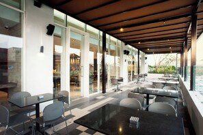 An indoor dining area with glass partitions, modern furniture, and a view of the outdoors.