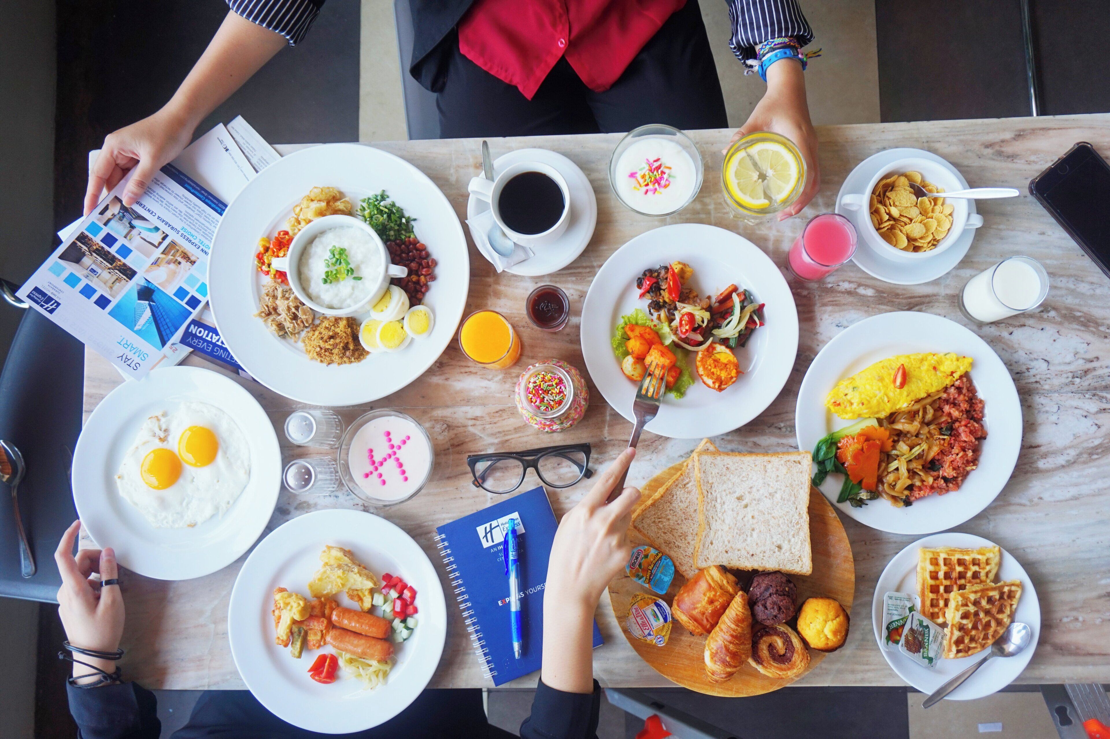 A table with various breakfast dishes, including eggs, toast, and cereal.