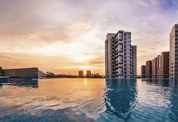 A high-rise building with a swimming pool in front. - Hilton Garden Inn Barranquilla (Barranquilla)