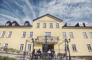 A yellow building with the sign "HOTEL PANTIJAR" and a balcony with tables and chairs. - Hotel Puntijar (Zagreb)
