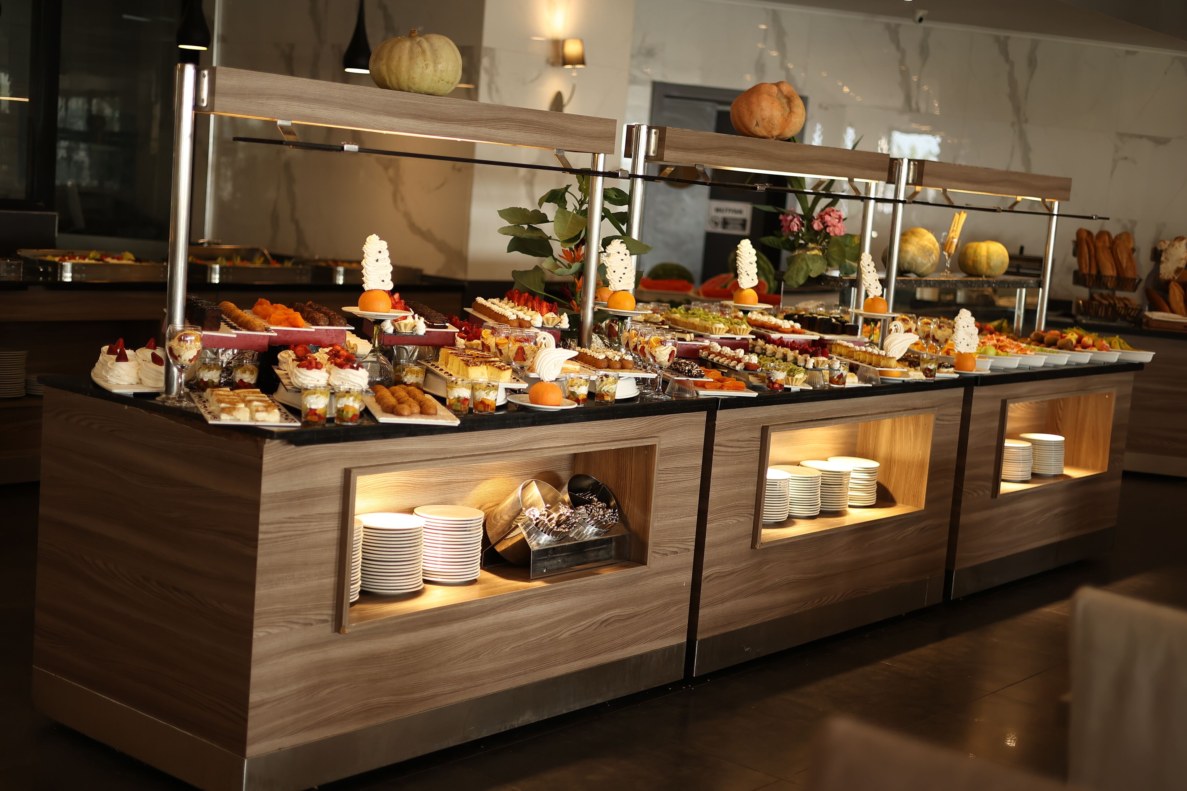 A buffet with various food items and a decorative pumpkin.