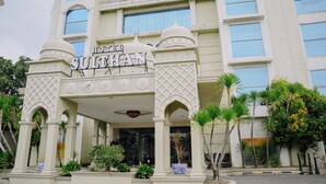 L’extérieur de l’hôtel Sulthan présente une architecture traditionnelle, avec des entrées en arc de cercle et des éléments décoratifs.