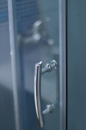 A metallic handle on a glass door, likely part of a bathroom or shower enclosure. - Hotel Opera (Larnaca)
