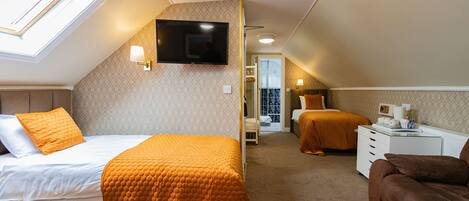A bedroom with a bed, a sofa, a TV, and a desk.