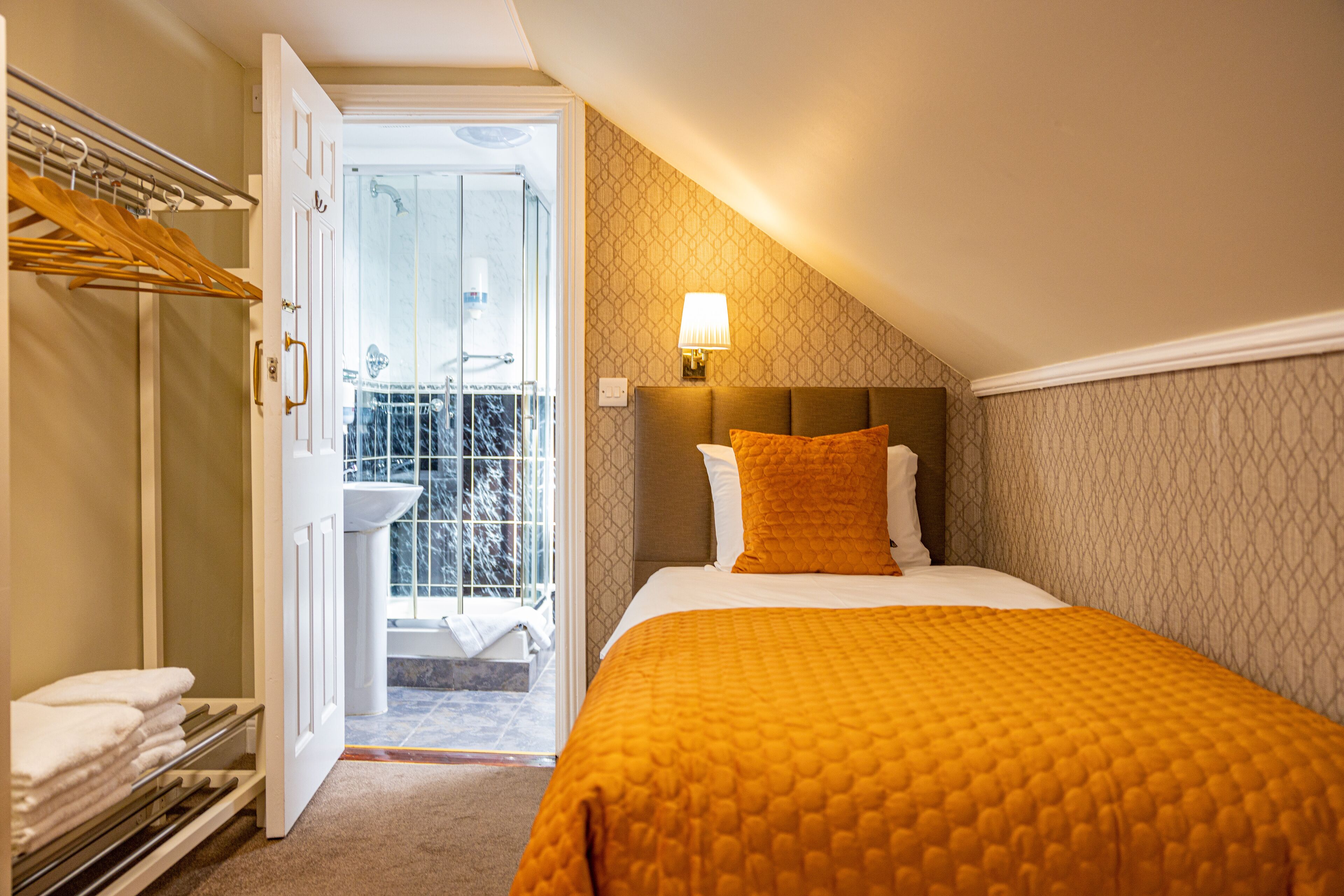 Une chambre d’hôtel avec un lit, une salle de bain et un balcon.