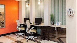 A modern office space with a desk, two chairs, a computer, and a decorative plant. - Holiday Inn Express & Suites Eureka by IHG (Eureka)