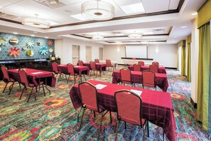 A conference room with tables and chairs, a projector screen, and a patterned carpet. - Holiday Inn Express & Suites Eureka by IHG (Eureka)