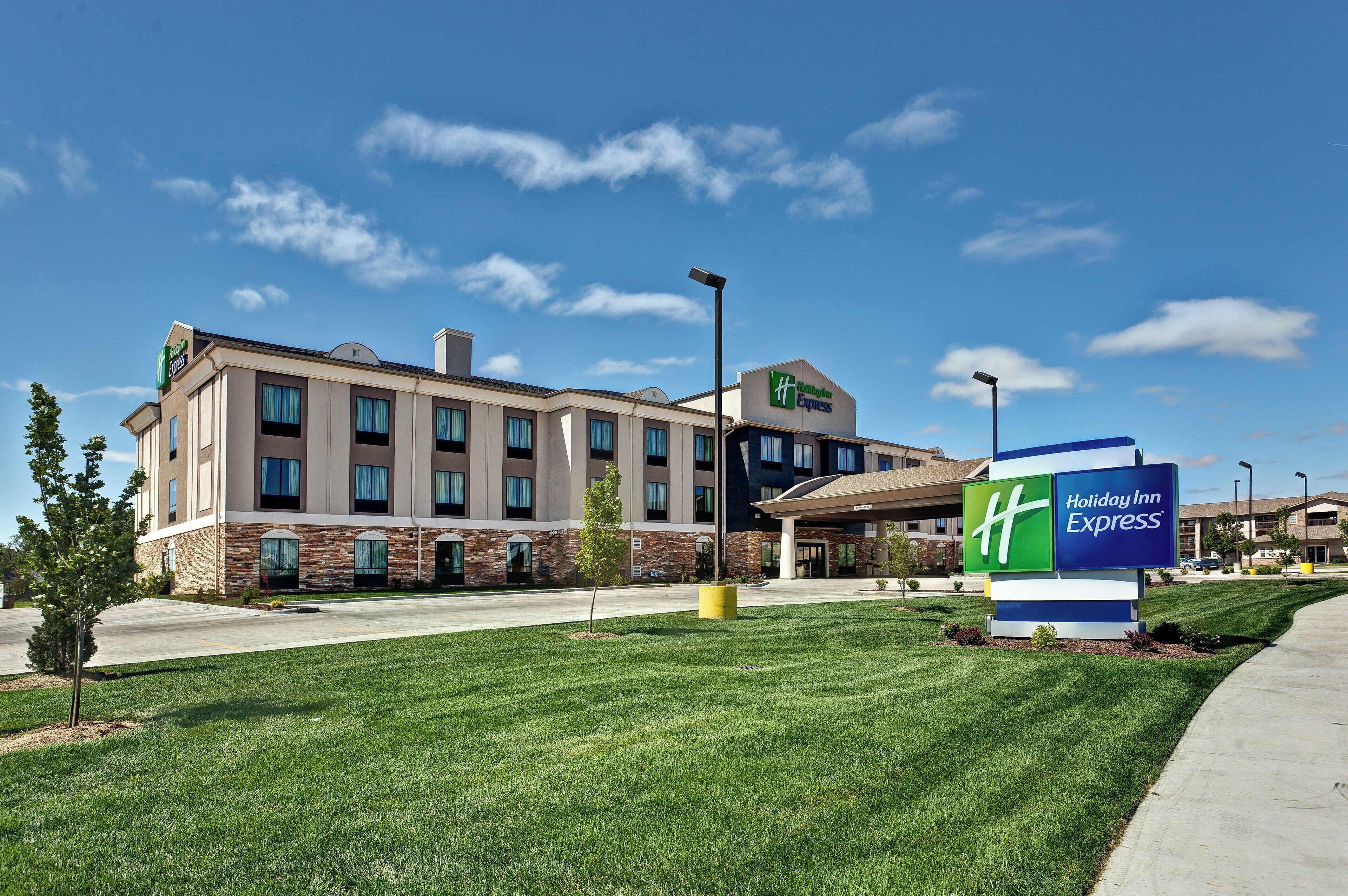 A Holiday Inn Express hotel with a modern design, featuring a brick facade and a clear blue sky.