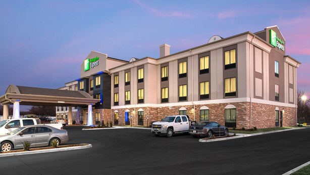 A Holiday Inn Express hotel with a parking lot and several cars parked in front. - Holiday Inn Express Hutchinson by IHG (Hutchinson)