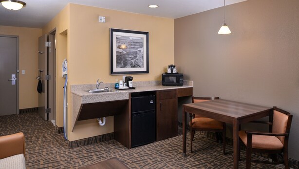 A compact hotel room with a kitchenette, a dining area, and a bed. - Holiday Inn Express & Suites Page - Lake Powell Area by IHG (Page)