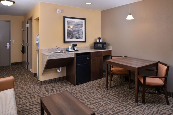 A compact hotel room with a kitchenette, a dining area, and a bed. - Holiday Inn Express & Suites Page - Lake Powell Area by IHG (Page)