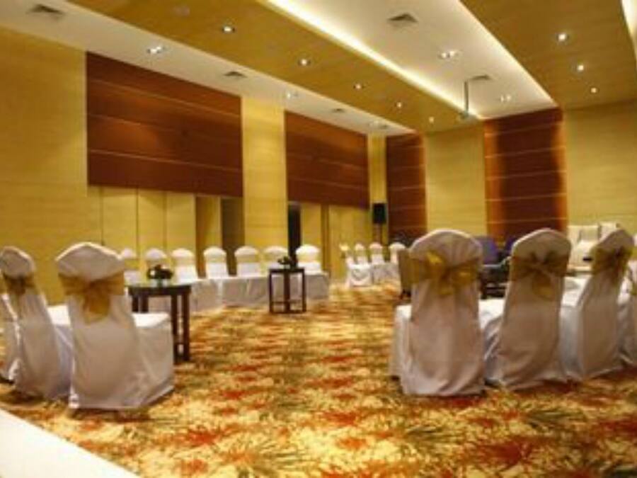 A conference room with rows of white chairs and a carpeted floor.