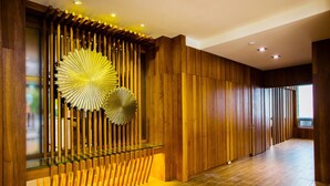A modern interior with wooden paneling, a glass railing, and a large decorative fan. - Lealea Garden Hotels - Sun Lake (Yuchi)