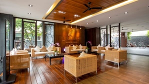A modern hotel lobby with wicker furniture, ceiling fans, and a large window offering a view of the outdoors. - Lealea Garden Hotels - Sun Lake (Yuchi)