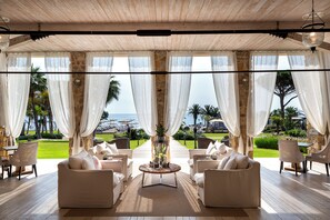 A spacious outdoor lounge area with a view of the sea, furnished with white sofas and chairs, and a central coffee table. - La Villa del Re - Adults Only - Small Luxury Hotels of the World (Castiadas)