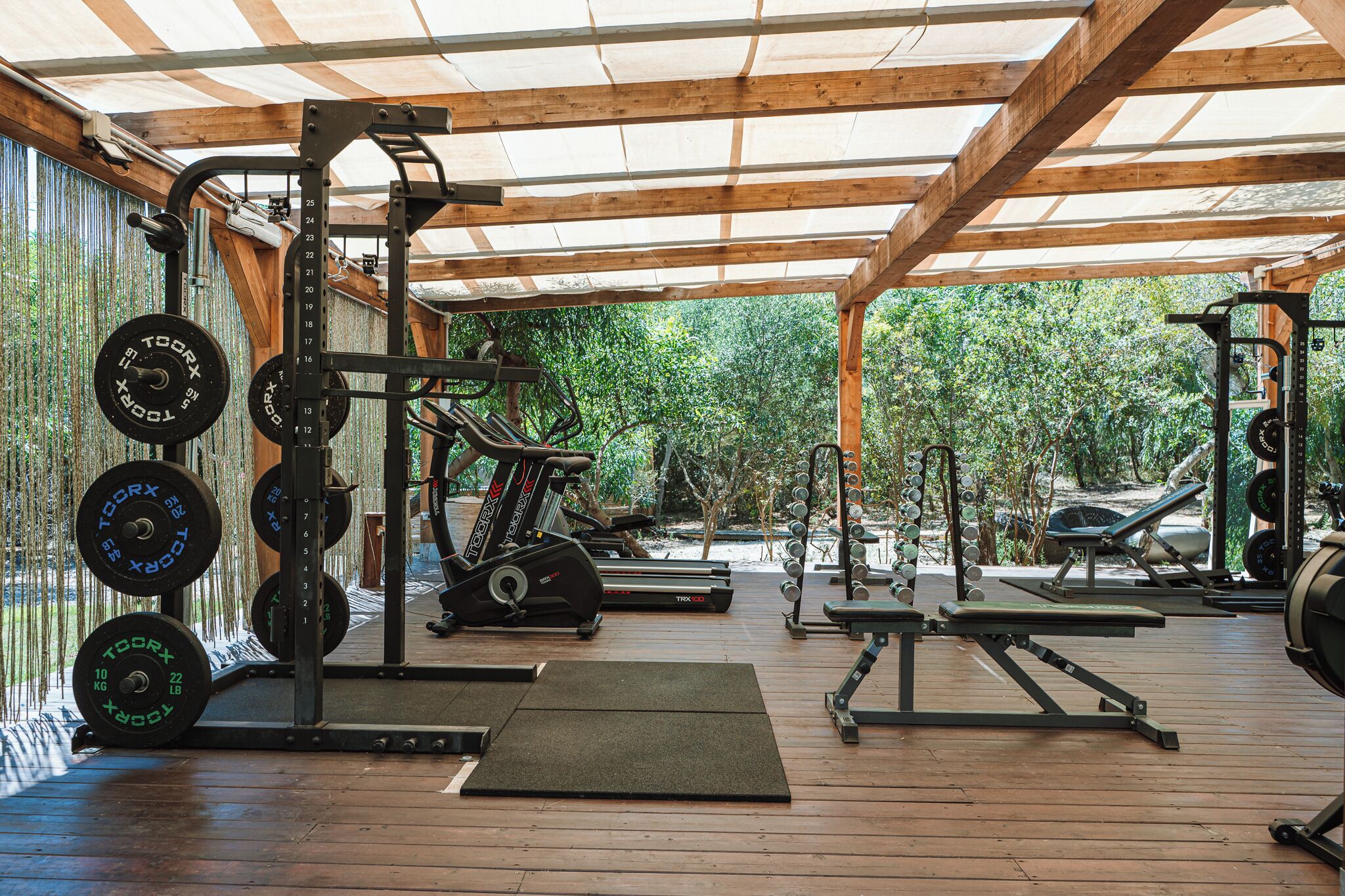 Un gimnasio techado con equipo de levantamiento de pesas y cintas de correr.