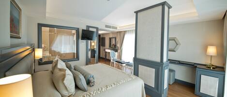 A hotel room with a large bed, bedside tables, a desk, and a shower area.