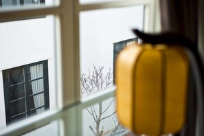 A window with a view of a building and bare trees outside.
