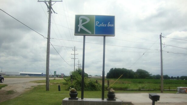 A sign for a Relax Inn with a parking symbol. - Relax Inn (Streator)
