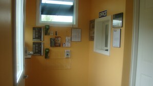 A hallway with a bulletin board, a window, and an 'OFFICE' sign. - Relax Inn (Streator)