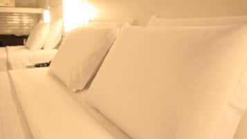 Ein Hotelzimmer mit einem ordentlich bezogenen Bett, einem Nachttisch und einer Lampe.