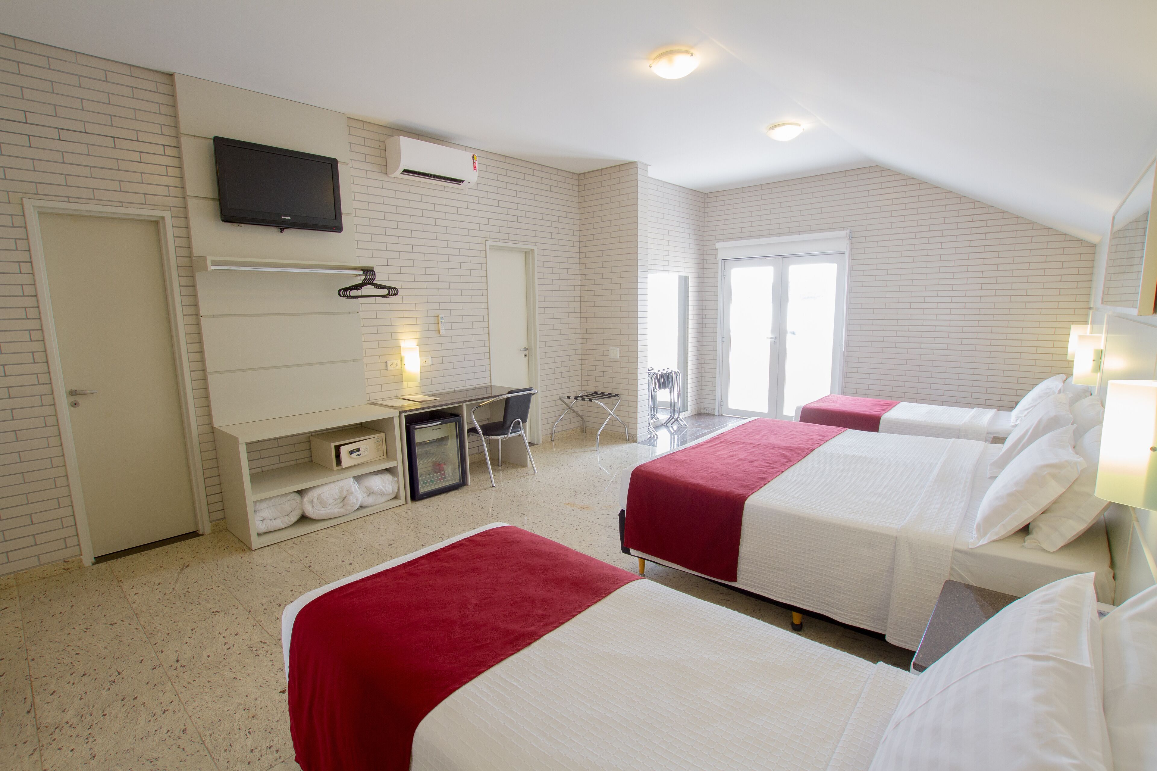 Habitación cuádruple estándar | Minibar, caja de seguridad en la habitación y escritorio 