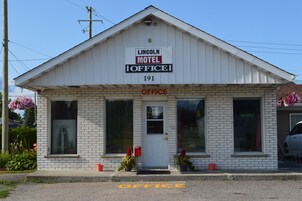 Un edificio blanco con un cartel que dice "Lincoln Motel Office" y el número 191.