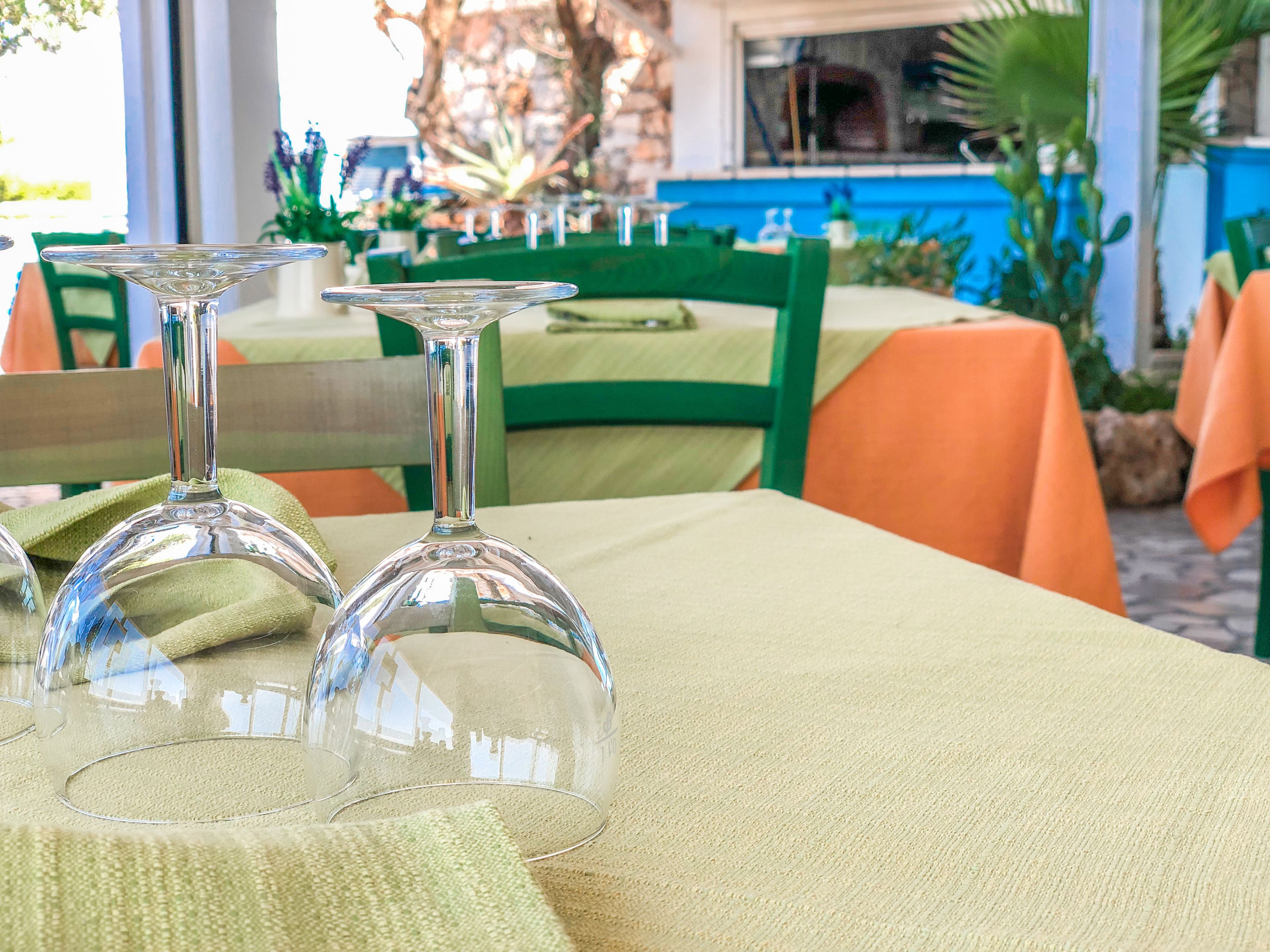 Una mesa de comedor con dos copas de cristal transparente y un mantel verde.