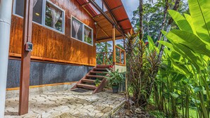 Una casa de madera con una escalera de piedra que conduce a un porche cubierto.