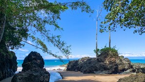 Una playa con formaciones rocosas y agua azul cristalina.
