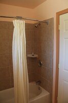 Un baño con bañera, ducha e inodoro.