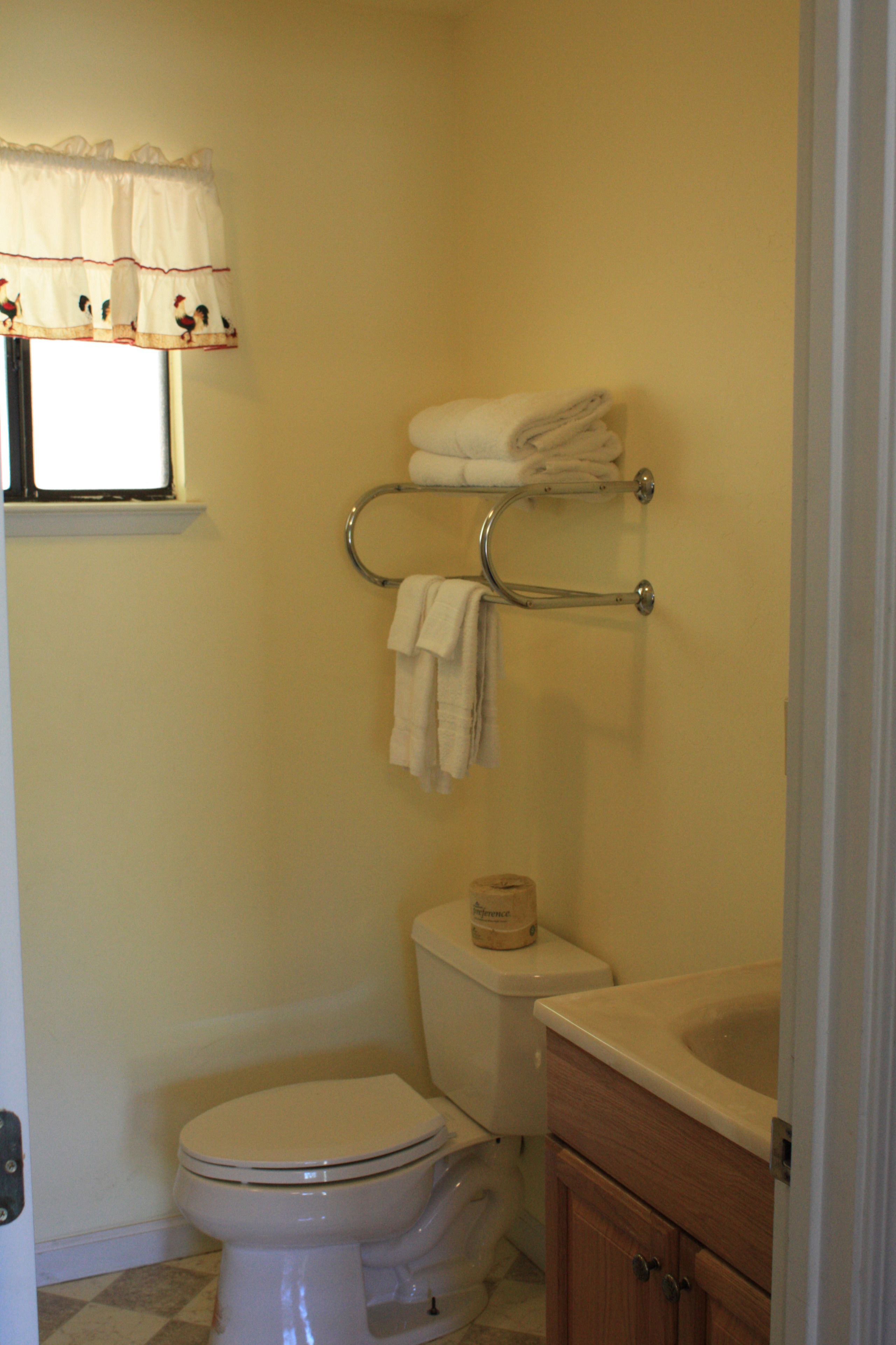 A bathroom with a toilet, a sink, and a towel rack.