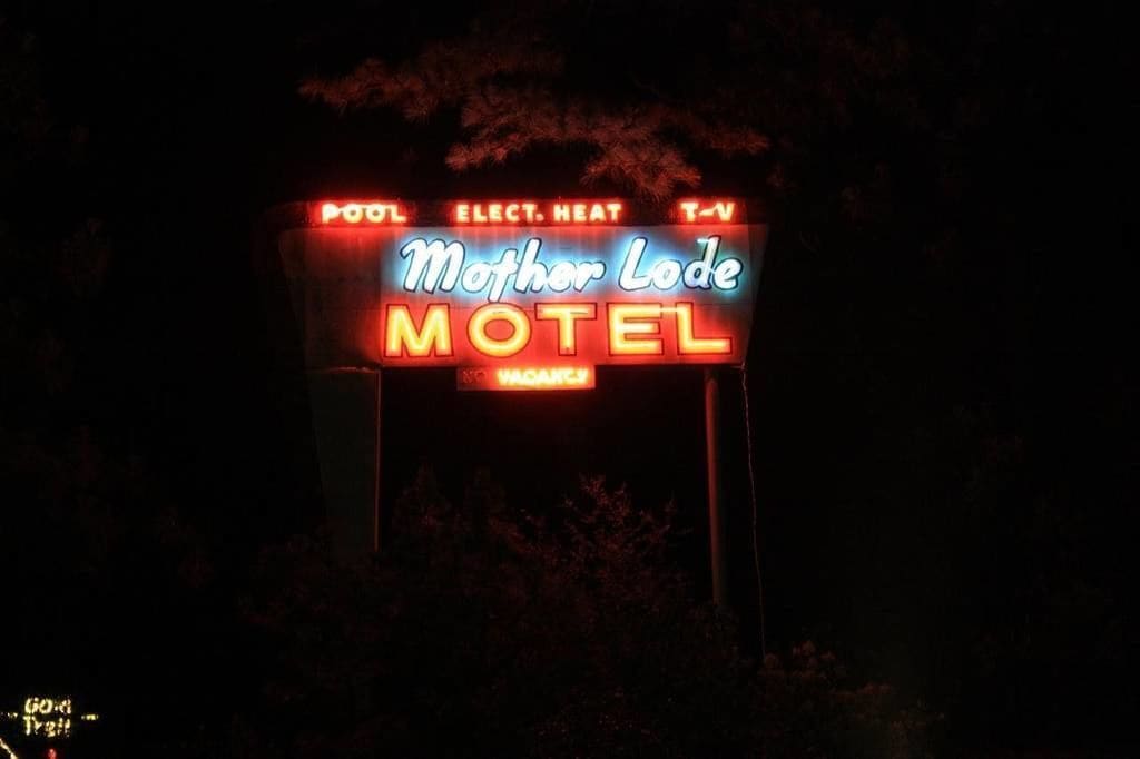 Letrero de neón del motel Mother Lode, con los servicios indicados: piscina, calefacción eléctrica, TV.