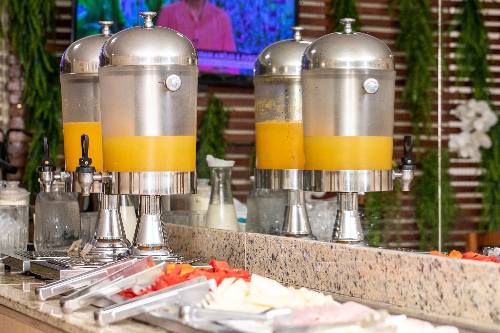 Una mesa de buffet con varios dispensadores de jugo y una variedad de alimentos.