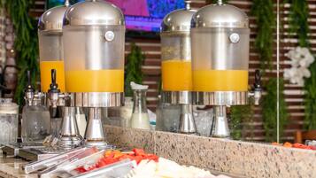 Una mesa de buffet con varios dispensadores de jugo y una variedad de alimentos.