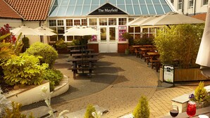 The Mayfield restaurant with outdoor seating, umbrellas, and a brick pathway. - Mayfield Hotel (Scarborough)