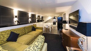 A compact living space with a sofa, dining table, and kitchenette. - Mayfield Hotel (Scarborough)