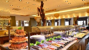 A buffet with various food items and a decorative horse statue. - Side Crown Serenity Ultra All Inclusive (Manavgat)