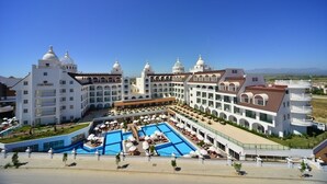 A large resort with multiple domed buildings, a central pool area, and outdoor seating. - Side Crown Serenity Ultra All Inclusive (Manavgat)