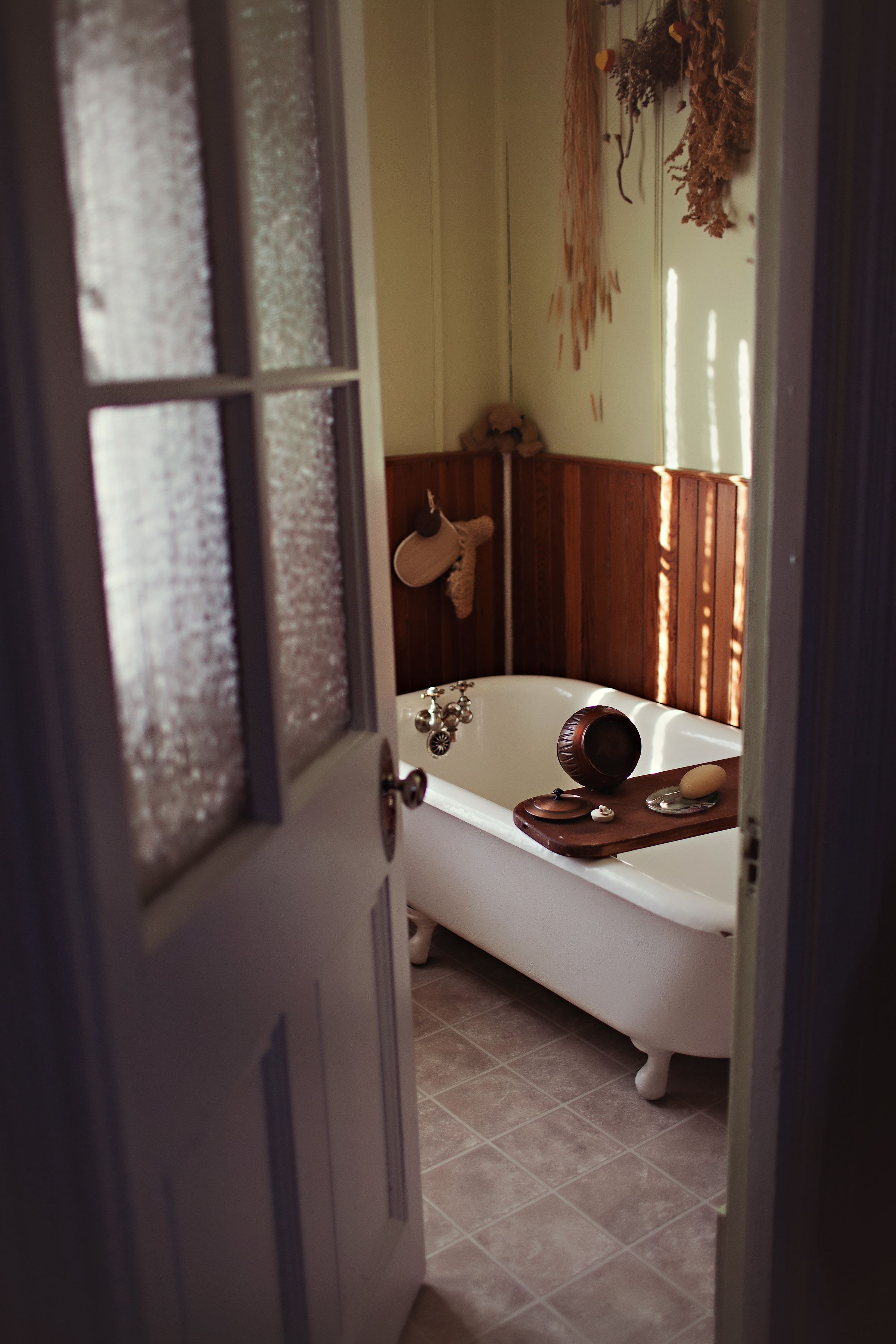 Ein Badezimmer mit einer weißen Badewanne, Holzvertäfelung und einem Handtuchhalter.