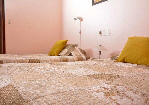 A bedroom with two beds, a lamp, and a wall socket. - Hotel San Francisco de la Selva (Copiapó)